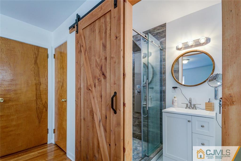 106 Rector Street Perth Amboy, NJ 08861 - Photo 11 of 20 a bathroom with a sink a mirror a vanity and a shower