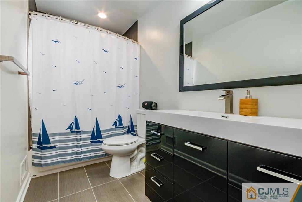 106 Rector Street Perth Amboy, NJ 08861 - Photo 14 of 20 a bathroom with a sink mirror and toilet