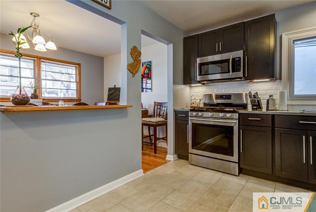 106 Rector Street Perth Amboy, NJ 08861 - Photo 3 of 20 a kitchen with stainless steel appliances a stove a microwave and cabinets
