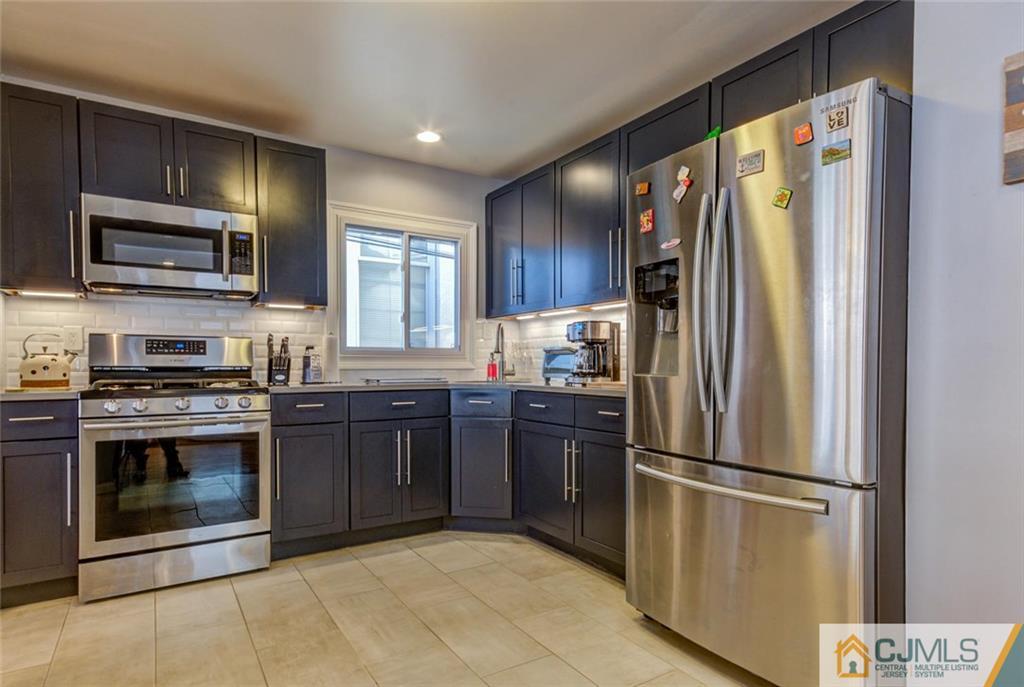 106 Rector Street Perth Amboy, NJ 08861 - Photo 4 of 20 a kitchen with stainless steel appliances granite countertop a refrigerator stove and microwave