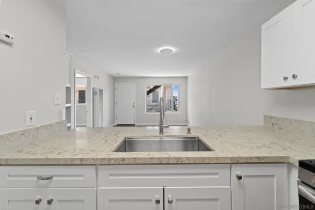 a kitchen with granite countertop a sink and cabinets