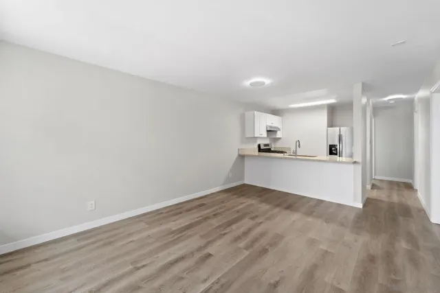 a view of kitchen with kitchen island white cabinets and wooden floor