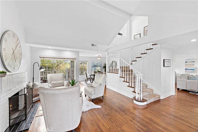 a living room with furniture a fireplace and a large window
