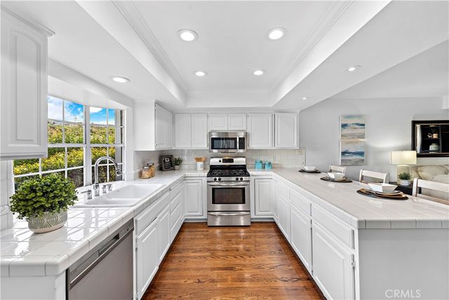 a large kitchen with stainless steel appliances lots of counter space sink and a stove