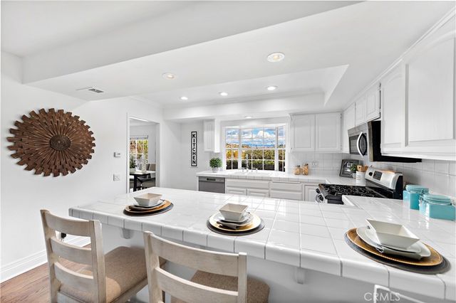 a kitchen with stainless steel appliances kitchen island granite countertop a table and chairs