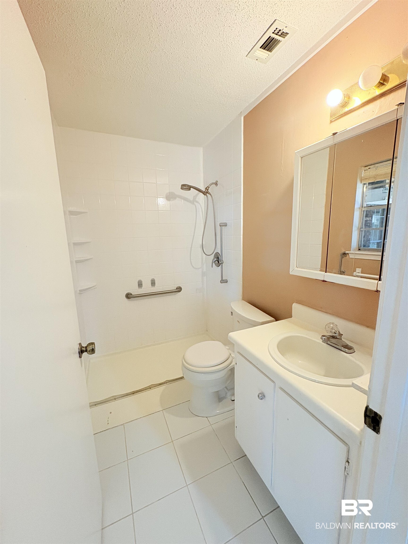 8070 Middle Ring Road Mobile, AL 36619 - Photo 17 of 26 Bathroom featuring tiled shower, vanity, a textured ceiling, and tile patterned floors