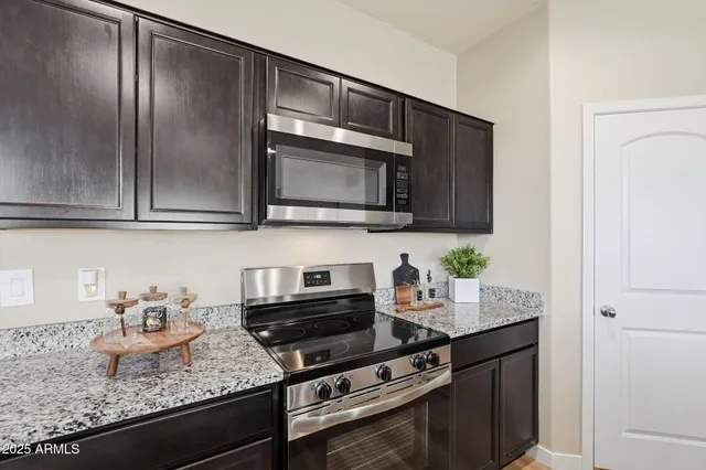 a kitchen with granite countertop cabinets a microwave and stove