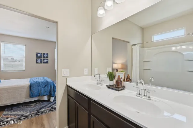 a bathroom with a bathtub shower sink vanity mirror and toilet