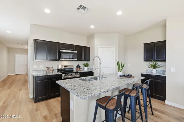a kitchen with granite countertop kitchen island cabinets and wooden floor