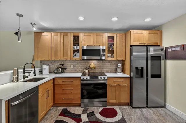 a kitchen with a sink a refrigerator and cabinets