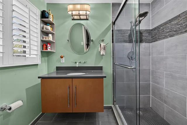 a bathroom with a sink a mirror and shower