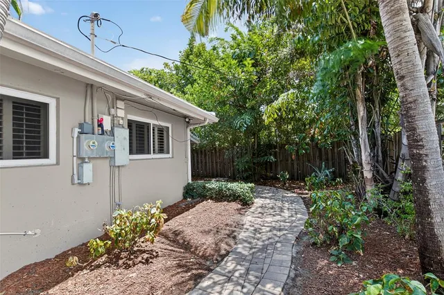 a view of a house with a yard and potted plants
