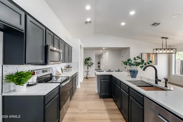 a kitchen with granite countertop a sink stove and cabinets