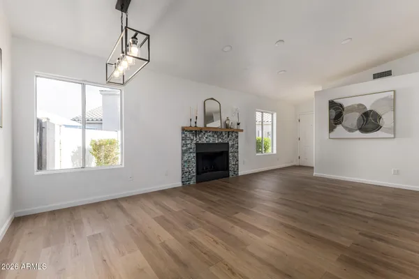 a view of empty room with wooden floor fireplace and windows