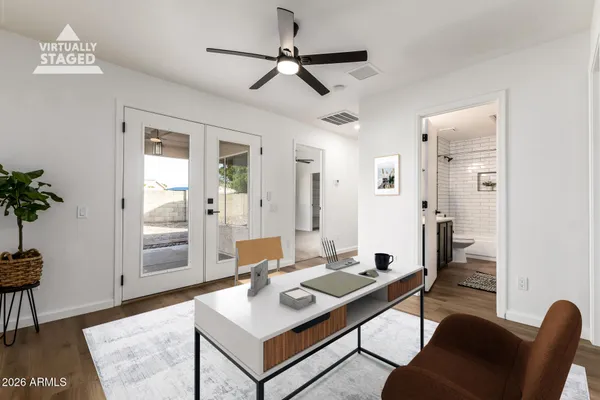a view of empty room with wooden floor and fan