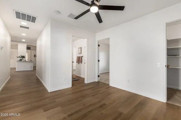 an empty room with wooden floor and chandelier fan