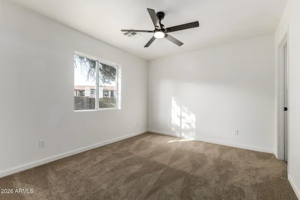 a view of a room with a ceiling fan and a bathroom