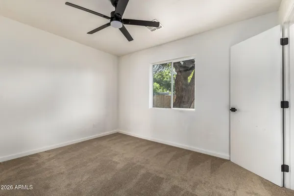 a view of a big room with wooden floor and windows