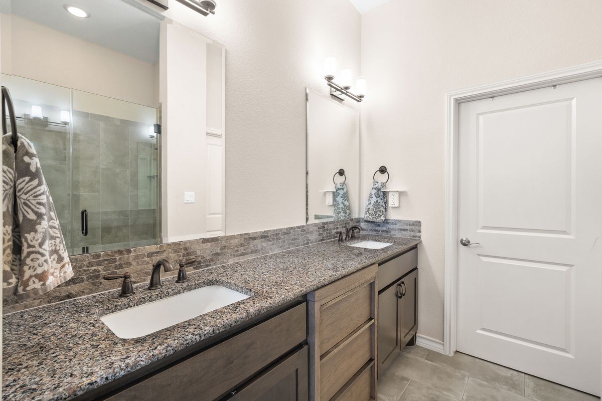 1116 Highknoll Lane Georgetown, TX 78628 - Photo 22 of 36 a bathroom with a granite countertop sink and a mirror