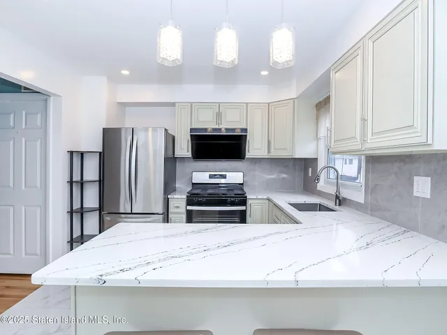 a kitchen with stainless steel appliances granite countertop a refrigerator a stove a sink and a granite counter tops