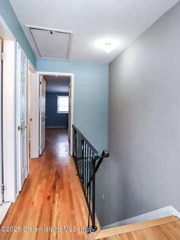 a view of a hallway with wooden floor and staircase