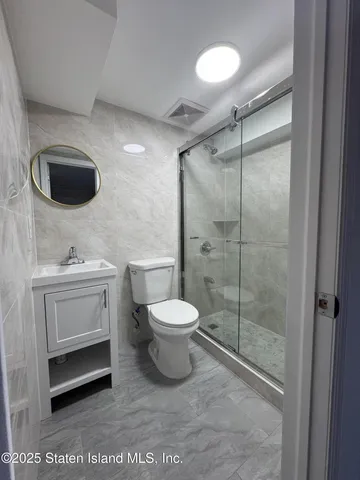 a bathroom with a toilet sink a mirror and shower