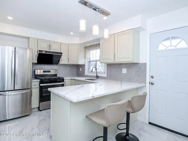 a kitchen with kitchen island a sink stove and refrigerator