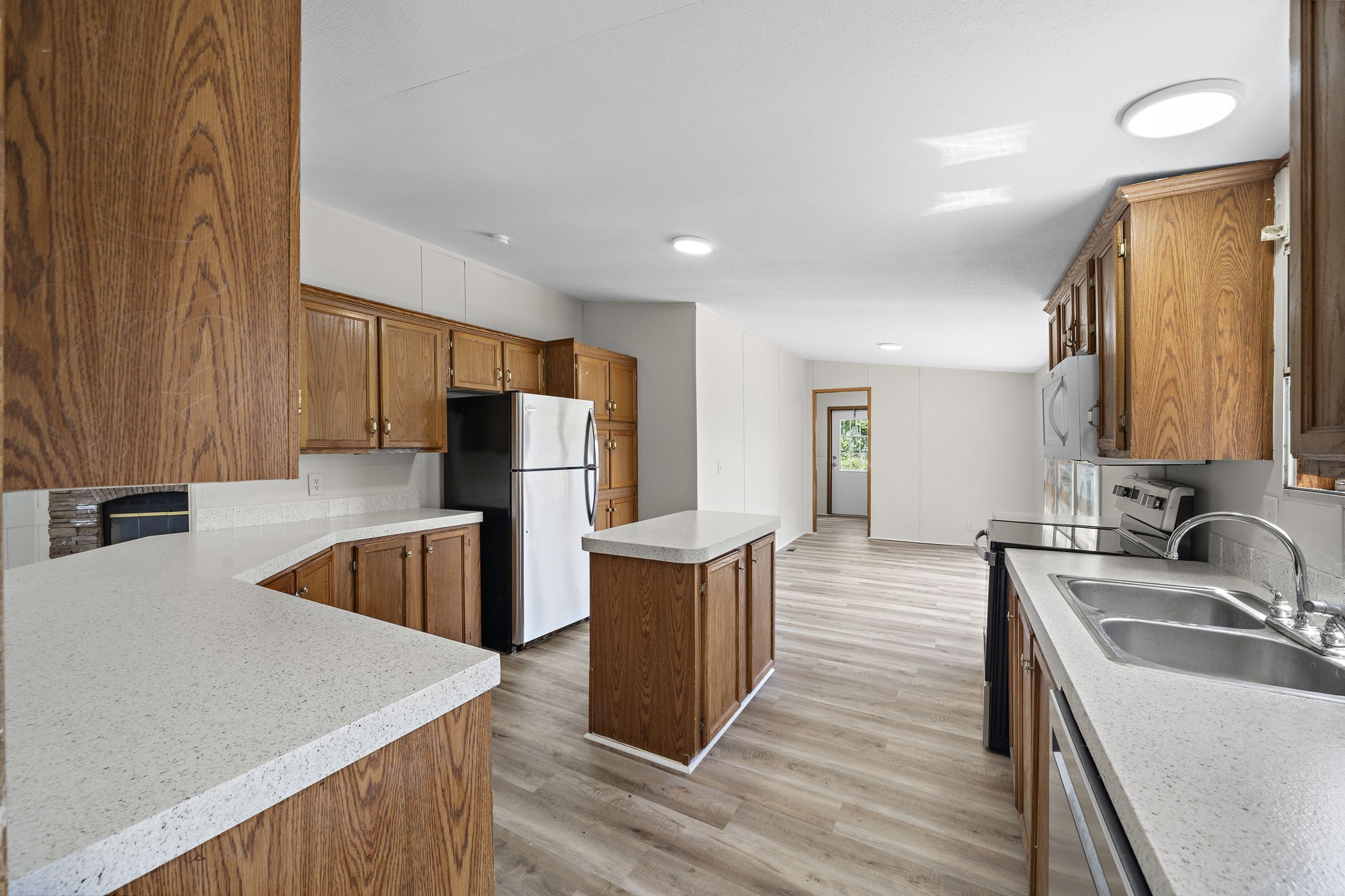 16482 Pisces Road Conroe, TX 77306 - Photo 13 of 35 a kitchen with stainless steel appliances granite countertop a sink dishwasher and a refrigerator with wooden floor