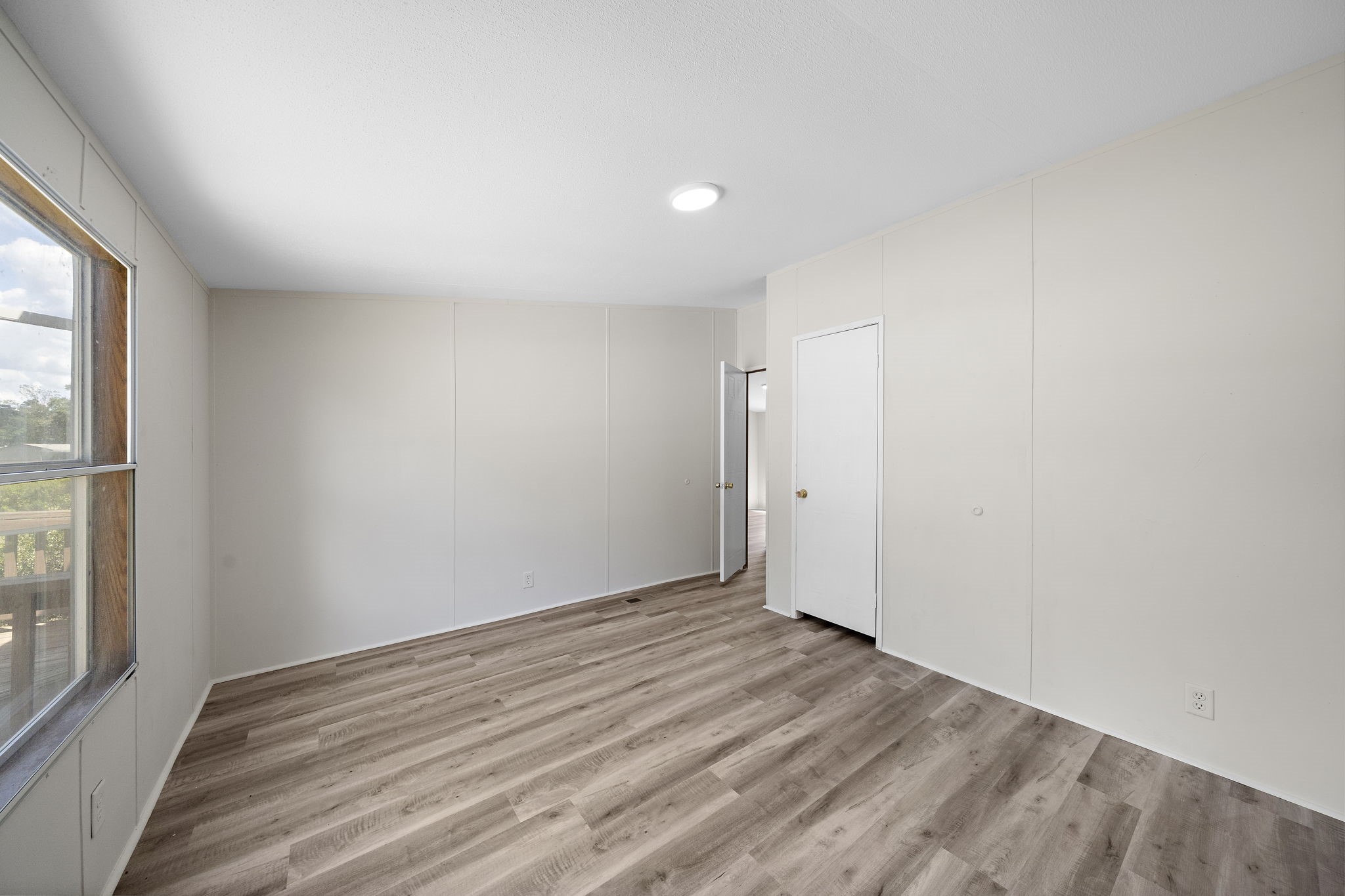 16482 Pisces Road Conroe, TX 77306 - Photo 31 of 35 an empty room with wooden floor and windows