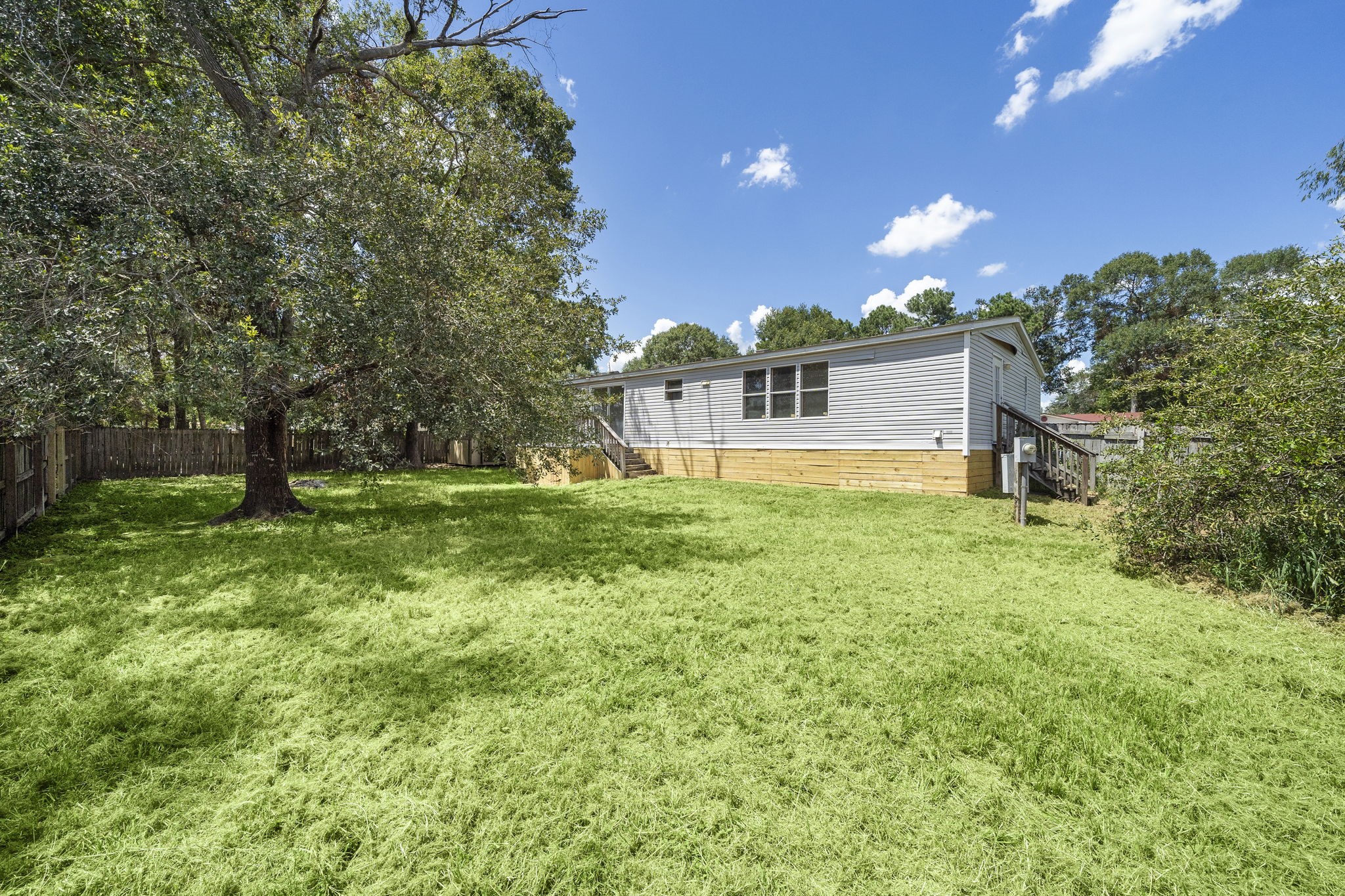 16482 Pisces Road Conroe, TX 77306 - Photo 32 of 35 a view of a house with a yard and a tree