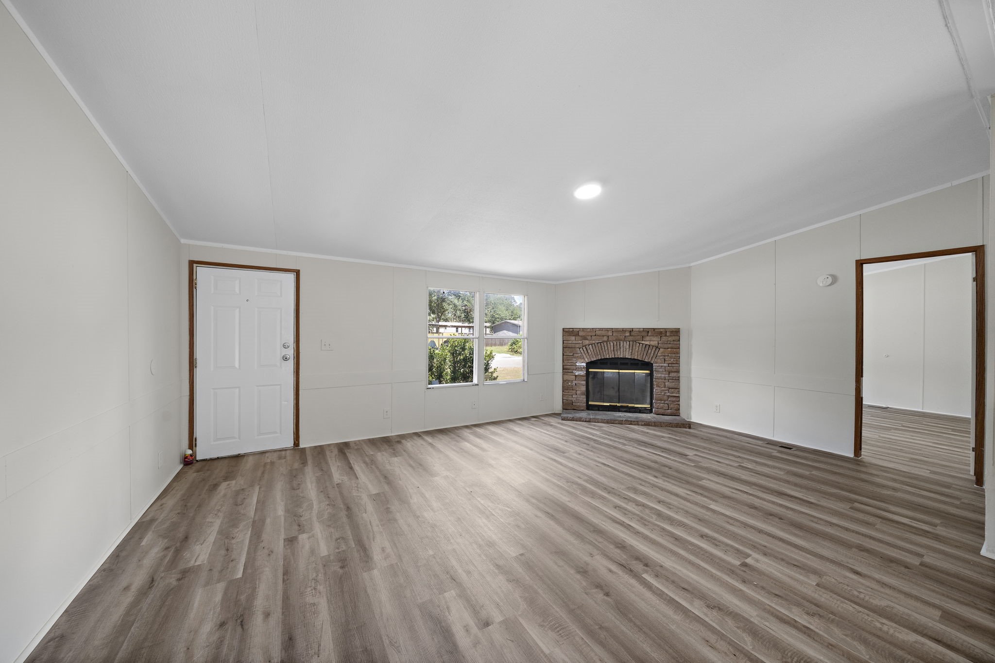 16482 Pisces Road Conroe, TX 77306 - Photo 6 of 35 an empty room with wooden floor fireplace and windows