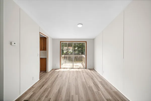 a view of a room with wooden floor and windows