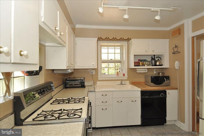 1807 Myrtle Road Silver Spring, MD 20902 - Photo 12 of 27 a kitchen with a stove and white cabinets