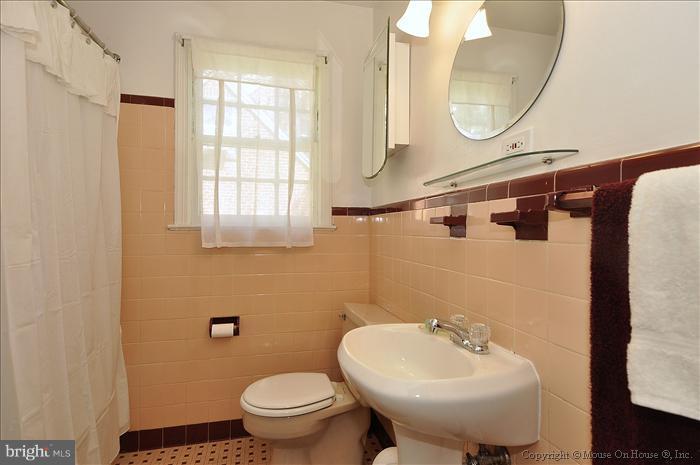 1807 Myrtle Road Silver Spring, MD 20902 - Photo 22 of 27 a bathroom with a sink a mirror a toilet and a window