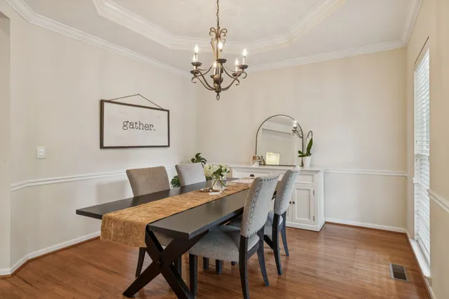 a view of a dining room with furniture a chandelier and wooden floor