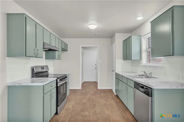 a kitchen with a sink stove and cabinets