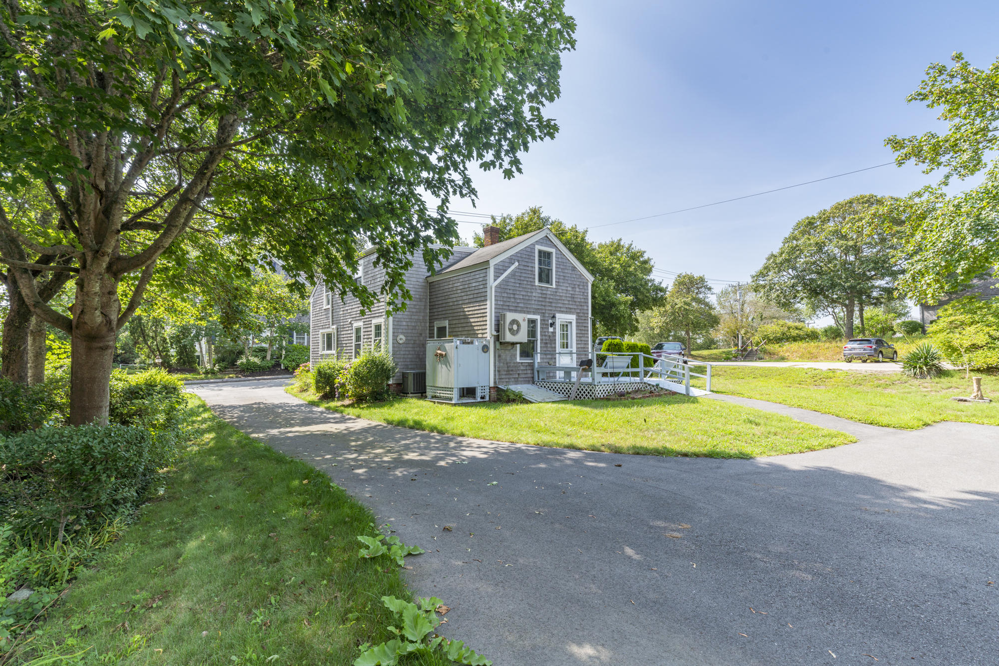 77 Queen Anne Road Chatham, MA 02633 - Photo 8 of 28 a view of yellow house with a big yard and large trees