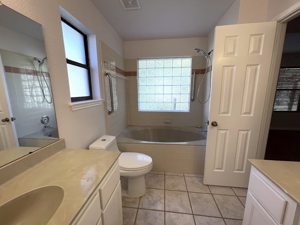 5001 Blue Bluff Road Austin, TX 78724 - Photo 17 of 28 a bathroom with a sink a bathtub a toilet a window and vanity