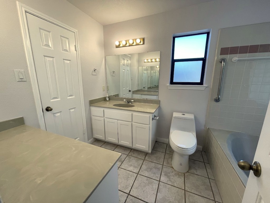 5001 Blue Bluff Road Austin, TX 78724 - Photo 18 of 28 a bathroom with a toilet sink a mirror and vanity