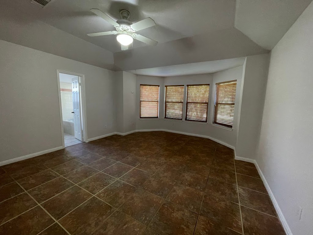 5001 Blue Bluff Road Austin, TX 78724 - Photo 19 of 28 en empty room with windows and ceiling fan