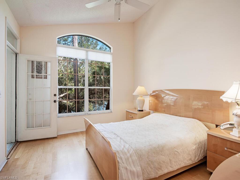 65 Silver Oaks Circle, Unit 11202 Naples, FL 34119 - Photo 11 of 12 a bedroom with a bed and a large window