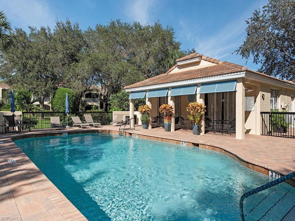 65 Silver Oaks Circle, Unit 11202 Naples, FL 34119 - Photo 3 of 12 swimming pool view with a seating space and a garden view