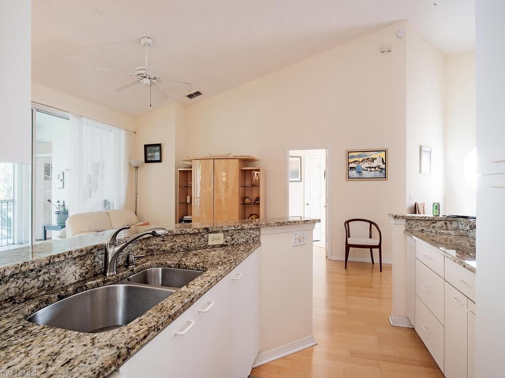 65 Silver Oaks Circle, Unit 11202 Naples, FL 34119 - Photo 6 of 12 a kitchen with granite countertop a sink and cabinets