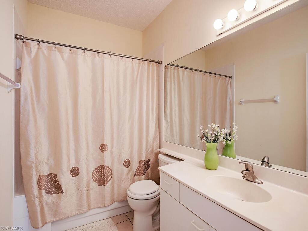 65 Silver Oaks Circle, Unit 11202 Naples, FL 34119 - Photo 10 of 12 a bathroom with a sink toilet and shower