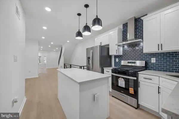 a kitchen with stainless steel appliances a stove sink and refrigerator