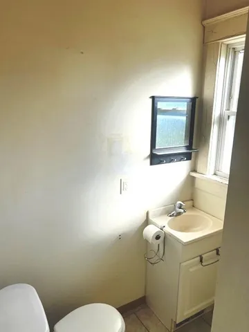 a bathroom with a toilet sink and mirror