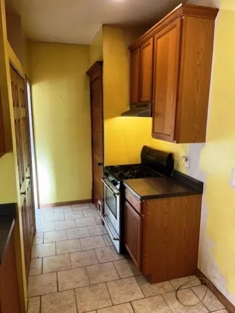 a kitchen with a sink a stove top oven and a refrigerator
