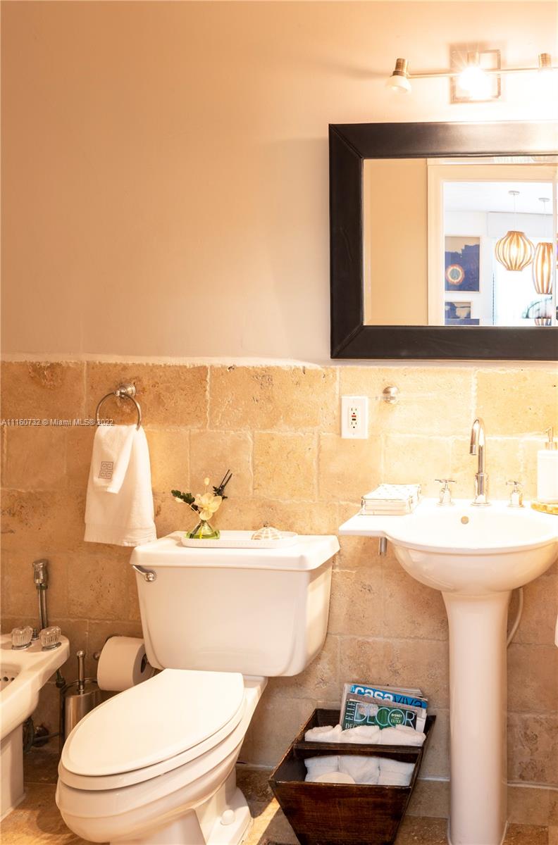 4216 Alton Road Miami Beach, FL 33140 - Photo 13 of 27 a bathroom with a sink a mirror and a toilet