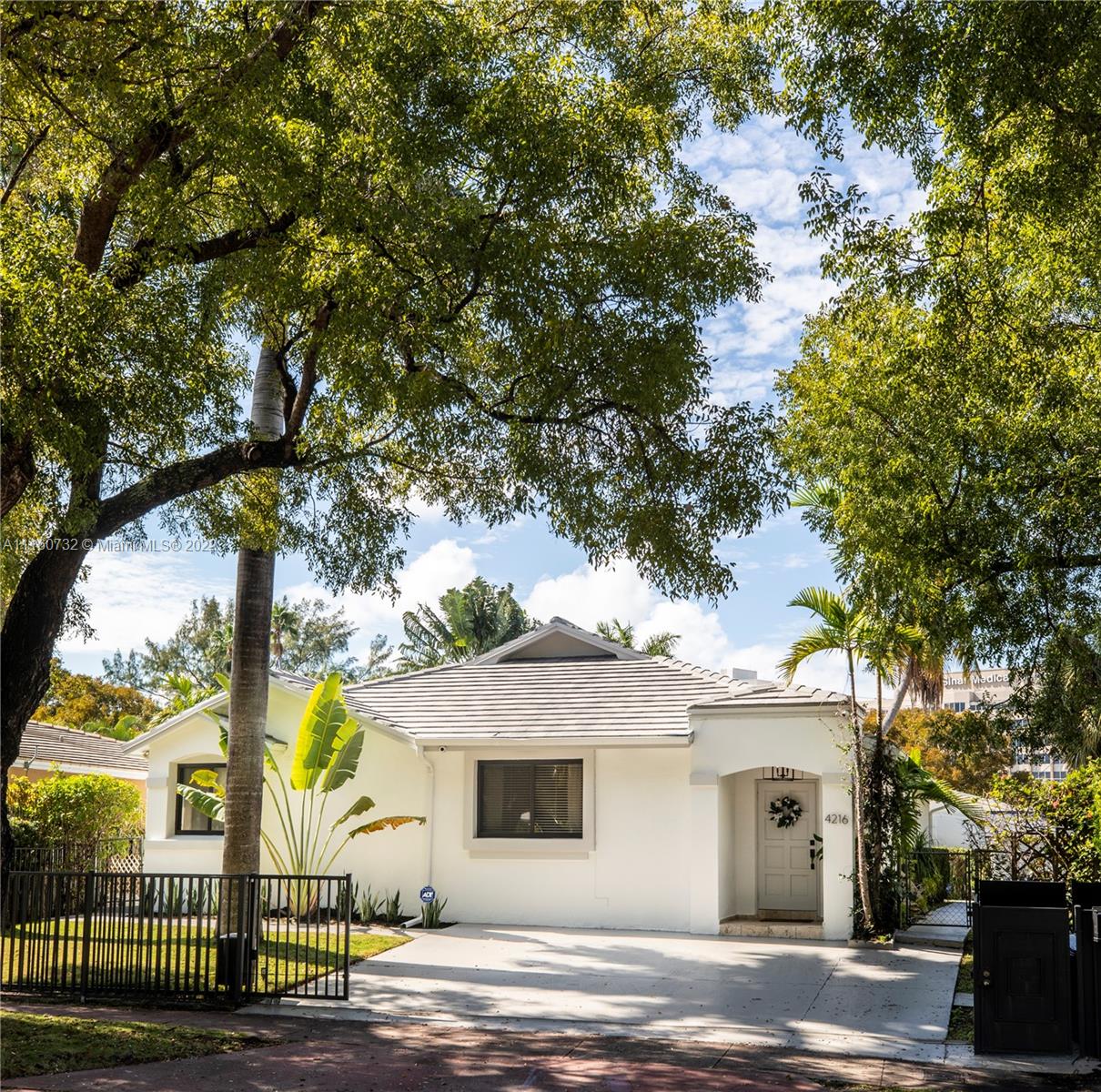 4216 Alton Road Miami Beach, FL 33140 - Photo 22 of 27 a front view of a house with a garden