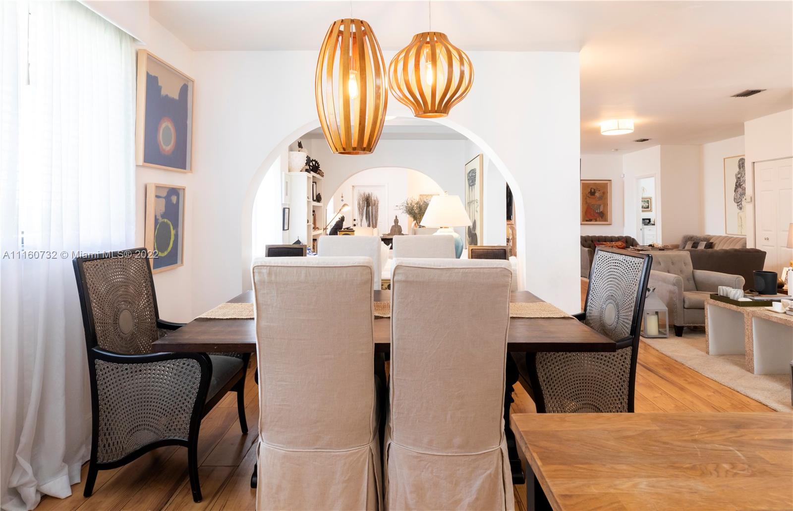4216 Alton Road Miami Beach, FL 33140 - Photo 9 of 27 a dining room with furniture a rug and a chandelier